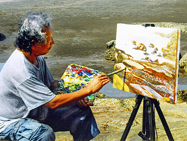 Họa sĩ Lê Bá Hạnh bên một bức tranh vẽ biển.