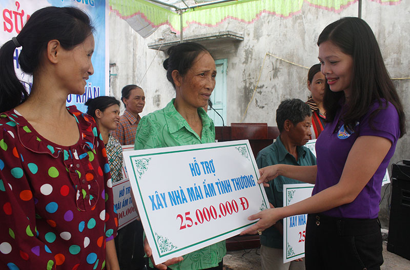 Chị Phạm Thị Thanh Mai, Chủ tịch Hội LHPN TP Hạ Long trao biển tượng trưng phần tiền hỗ trợ cho các hộ xây mới nhà