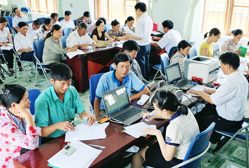 Cán bộ NHCSXH huyện Hải Hà làm thủ tục giải ngân vốn vay cho khách hàng.