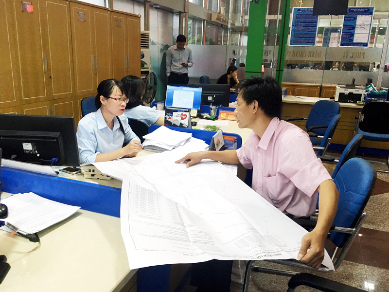 Cán bộ Sở Tài nguyên & Môi trường hướng dẫn khách hàng thực hiện thủ tục hành chính về đất đai tại Trung tâm Hành chính công tỉnh.