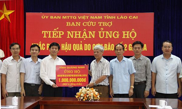 Đồng chí Phạm Văn Điệt, Chủ tịch Ủy ban Mặt trận Tổ quốc Việt Nam tỉnh Quảng Ninh trao tiền ủng hộ cho nhân dân tỉnh Lào Cai.