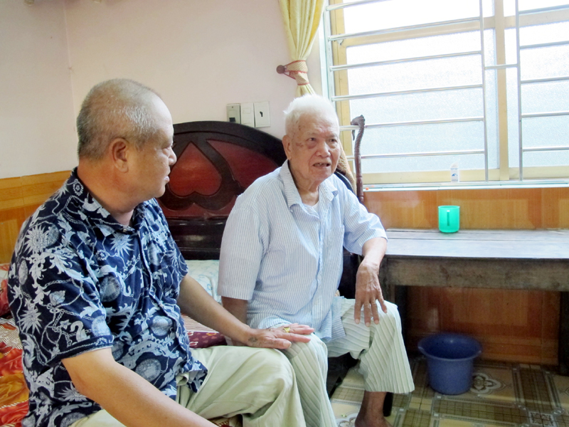Ông Đỗ Đức Quang (bên phải) và con trai ôn lại quãng thời gian tham gia cách mạng năm xưa.