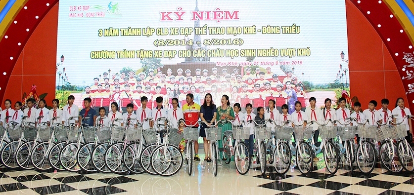 Học sinh nghèo TX Đông Triều phấn khởi nhận xe đạp từ các thành viên CLB xe đạp thể thao Mạo Khê.