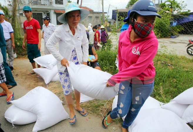 Ngư dân xã Phú Thuận, huyện Phú Vang, Thừa Thiên-Huế nhận gạo hỗ trợ. (Ảnh: Hồ Cầu/TTXVN)
