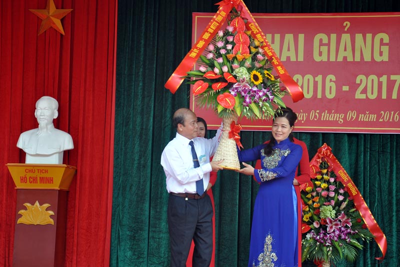 Đồng chí Đỗ Thị Lan, Phó Trưởng Đoàn ĐBQH tỉnh tặng hoa chúc mừng thầy và trò Trường THPT Quảng Hà nhân ngày khai giảng năm học mới.