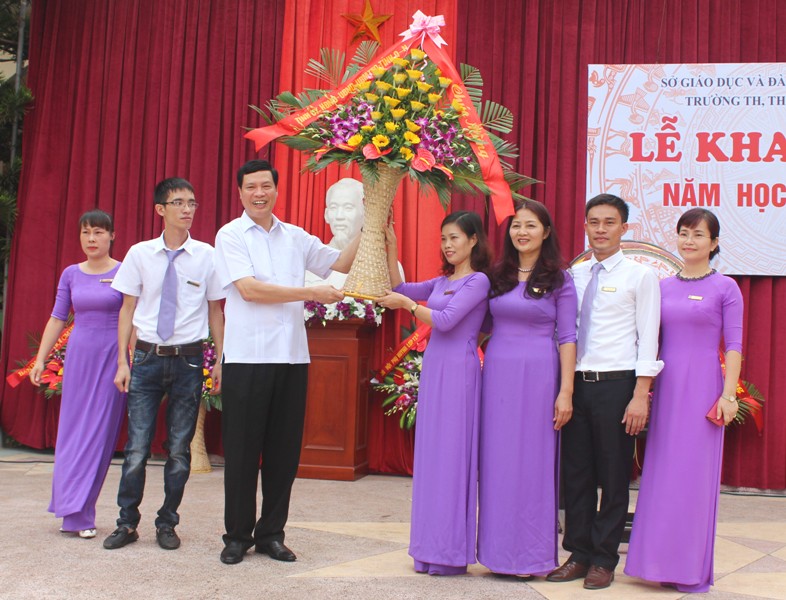 Đồng chí Nguyễn Đức Long, Chủ tịch UBND tỉnh tặng hoa chúc mừng thầy và trò trường TH, THCS, THPT Văn Lang