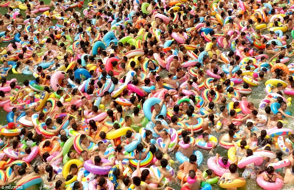 Một hồ bơi ở Tứ Xuyên đông nghịt người. Những người đi tắm cùng những chiếc phao đủ màu sắc đã phủ kín mặt nước. Ảnh: Reuters.