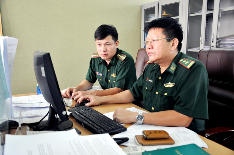 Trung tá Nguyễn Đình Thái (bên phải) cùng cán bộ của Ban Cửa khẩu rà soát các thủ tục liên quan đến công tác quản lý cửa khẩu trên địa bàn.