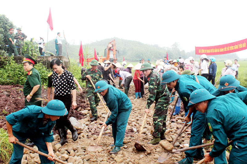 Cán bộ, chiến sĩ LLVT huyện Đầm Hà giúp người dân xã Tân Bình làm đường xây dựng nông thôn mới.