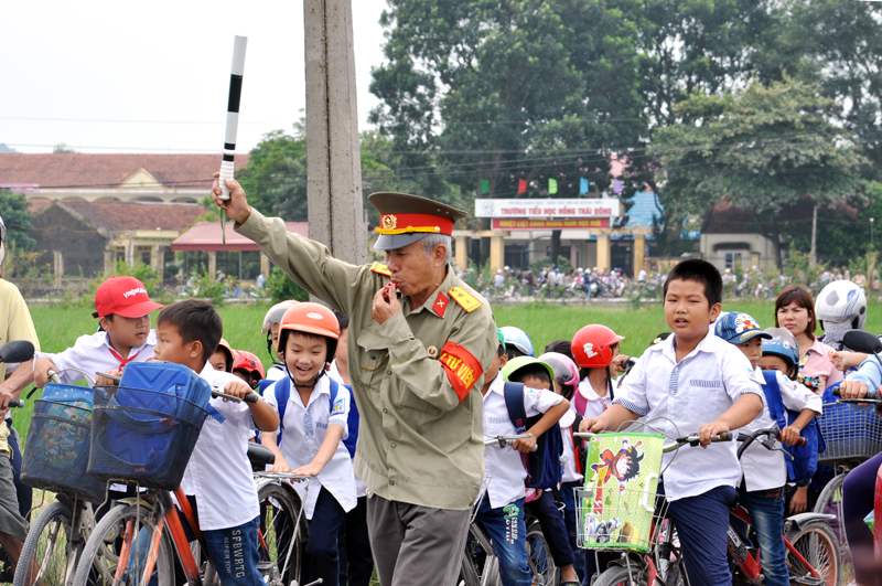 CCB Hoàng Thái Học và Phạm Đức Hạnh hướng dẫn học sinh sang đường đảm bảo an toàn giao thông.