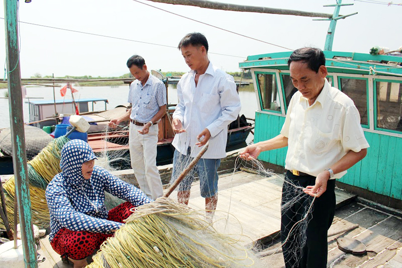 Bí thư Chi bộ thôn Nguyễn Đức Tính (ngoài cùng, bên phải) tuyên truyền, vận động nhân dân vươn khơi đánh bắt thuỷ sản, bảo vệ ngư trường, môi trường biển.