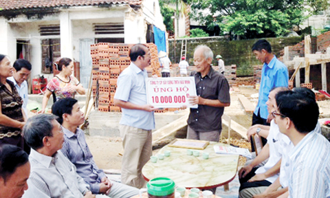 Ông Đào Duy Hảo, Chủ tịch Hiệp hội Doanh nghiệp TP Cẩm Phả, trao tiền ủng hộ các hộ nghèo xây nhà ở.
