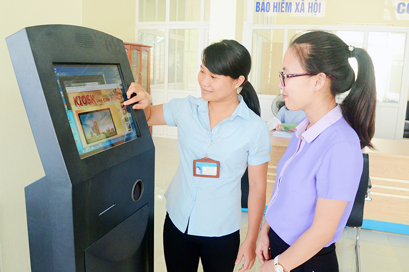 Cán bộ Trung tâm HCC huyện Hoành Bồ hướng dẫn công dân tra cứu thông tin trên kios điện tử.