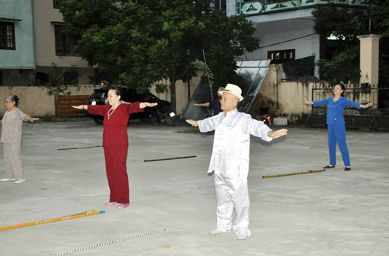 Cụ Nguyễn Ngọc Điện, Chủ tịch Hội Người cao tuổi phường Trần Phú (người đội mũ), cùng các hội viên người cao tuổi khu phố 2, tập thể dục dưỡng sinh.