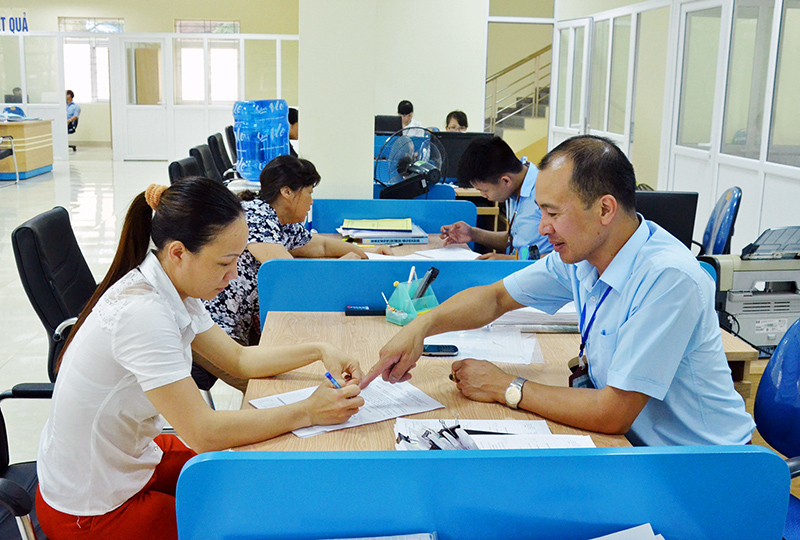 Cán bộ Trung tâm HCC huyện Hoành Bồ hướng dẫn người dân hoàn thiện hồ sơ TTHC.