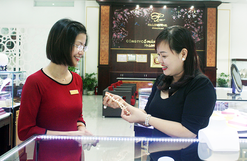 Chị Nguyễn Thuỳ Hương (bên phải) truyền đạt kiến thức về sản phẩm ngọc trai cho nhân viên bán hàng tại Trung tâm mua sắm Mỹ Ngọc, TP Hạ Long.