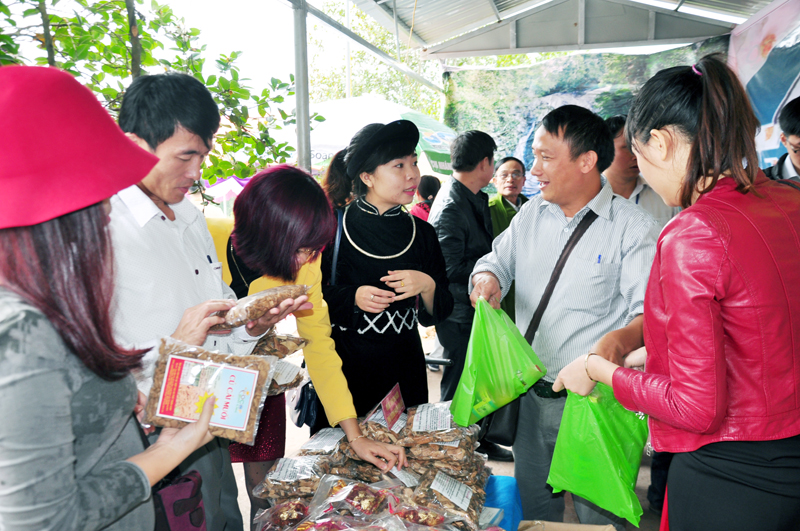 Du khách mua sản phẩm OCOP của địa phương tại lễ hội hoa sở huyện Bình Liêu, tháng 11-2015.