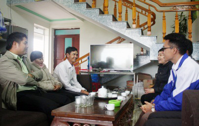 Cán bộ Tiểu ban Tuyên truyền - Vận động và xã Quảng Phong hỏi thăm tình hình đời sống sau tái định cư của hộ chị Vũ Thị Hằng, thôn 1 (thứ hai, trái sang).