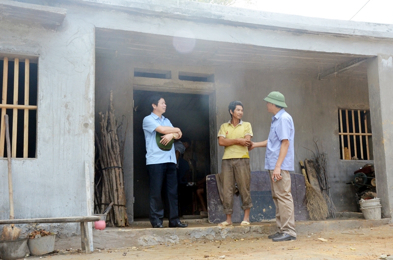 Lãnh đạo Ban Dân tộc tỉnh và Hội Nông dân tỉnh trò chuyện với anh Voòng Chí Thìn, xã Lục Hồn, huyện Bình Liêu (đứng giữa) bên ngôi nhà đang xây từ nguồn xi măng hỗ trợ của Viettel Quảng Ninh.