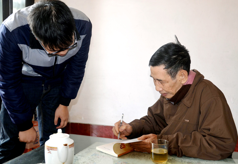 Nhà giáo ưu tú, nhà văn Hữu Tuân ký tặng sách cho một tác giả trẻ.