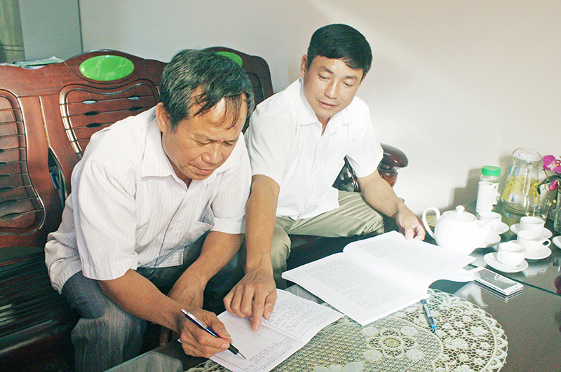 Đồng chí Hoàng Thanh Hùng, đảng uỷ viên Đảng uỷ xã Tình Húc hướng dẫn Trưởng thôn Chu Tiến Sàu (trái), khai hồ sơ xin vào Đảng.