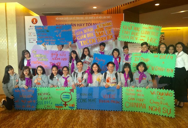 Các bạn sinh viên với những khẩu hiệu, thông điệp tại hội nghị quốc gia về tình dục, sức khỏe và xã hội. (Ảnh: PV/Vietnam+)