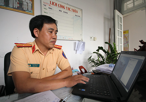 Thiếu tá Phạm Hồng Hải tranh thủ thời gian làm việc để quản trị trang Facebook của CSGT Đà Nẵng. Ảnh: Nguyễn Đông.
