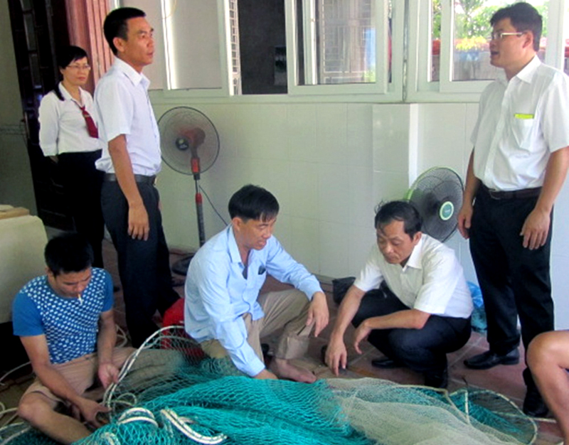 Lãnh đạo Ngân hàng Nhà nước chi nhánh Quảng Ninh hướng dẫn ngư dân Vân Đồn làm các thủ tục hồ sơ vay vốn.