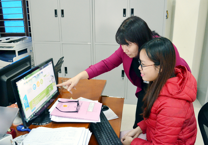 Cán bộ phường Cẩm Phú (TP Cẩm Phả) hướng dẫn công dân tham gia dịch vụ công trực tuyến mức độ 3.