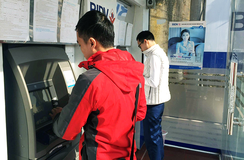 Khách hàng giao dịch ATM tại Ngân hàng BIDV (TP Hạ Long).