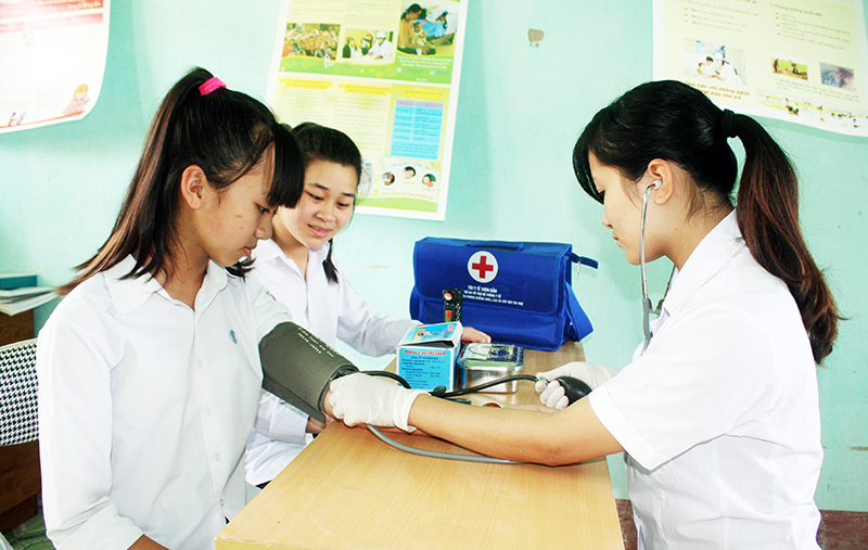 Cán bộ y tế Trạm Y tế xã Hải Xuân (TP Móng Cái) khám bệnh cho học sinh Trường THCS Hải Xuân. Ảnh: Nguyễn Dung