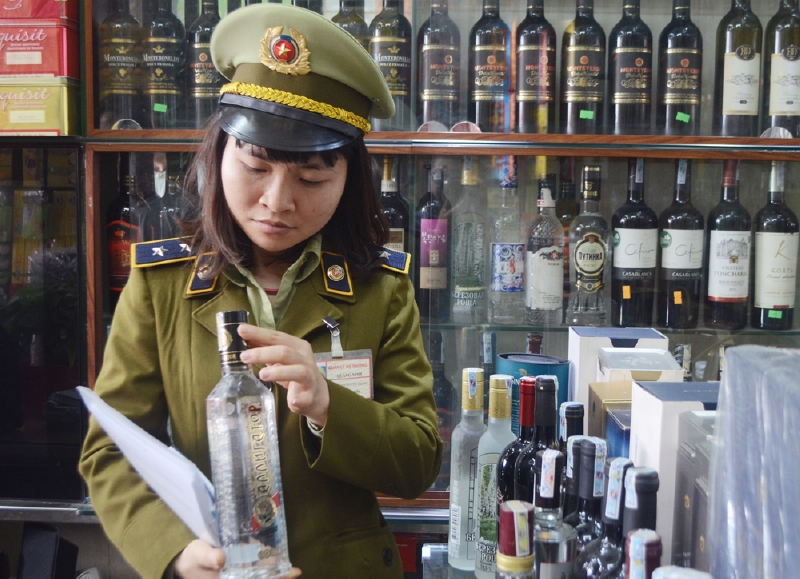 Kiểm tra tem nhãn các loại rượu tại đại lý của ông Phạm Trung Quý, phường Thanh Sơn. 