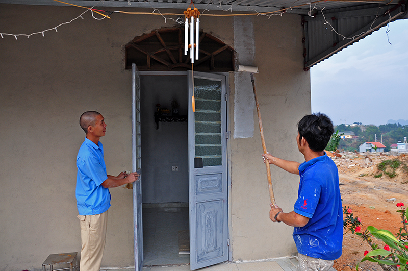 Anh Đỗ An Trang (bên trái) cùng thợ sơn hoàn thiện công việc cuối cùng để dọn về nhà mới trước Tết Nguyên đán. 