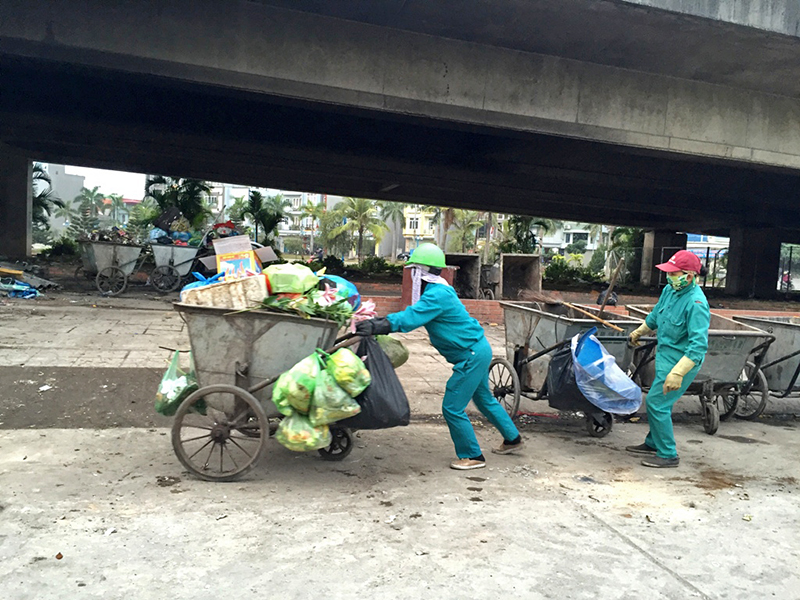 Nhân viên vệ sinh môi trường thu gom rác vào điểm tập kết chân cầu Bãi Cháy, TP Hạ Long. (Ảnh chụp lúc 17 giờ ngày 14-1-2017) 