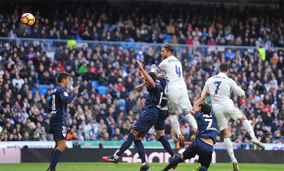 Ramos (số 4) bật cao mở tỷ số cho Real. Ảnh: Reuters