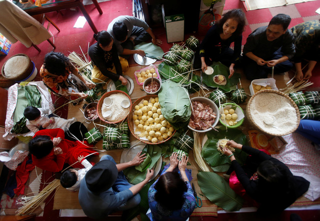 Gói bánh chưng cũng là một phong tục truyền thống của người dân Việt Nam mỗi dịp Tết đến, xuân về. Đây cũng là dịp để cả gia đình quây quần bên nhau và ôn lại một năm cũ đã qua (Ảnh: Reuters)