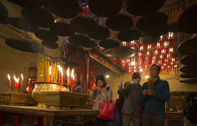 Người dân của nhiều nước châu Á thường đến những nơi thờ tự linh thiêng trong các ngày Tết để cầu xin những điều bình an và may mắn trong năm mới. Trong ảnh: người dân Hong Kong cầu khấn trong một ngồi đền (Ảnh: Reuters)