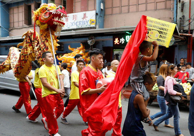 Những thanh thiếu niên đánh trống, múa lân trên đường phố ở khu phố của người Trung Quốc tại thủ đô Manila của Philippines. Múa lân là phong tục truyền thống thường có trong các dịp lễ, tết của người Trung Quốc. (Ảnh: Reuters)