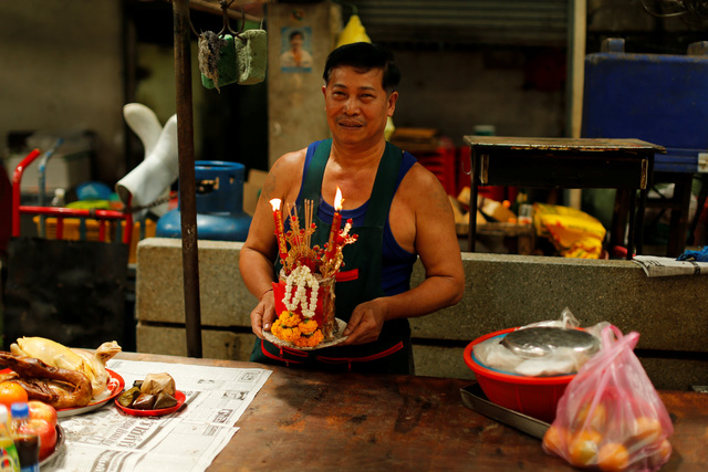 Một người đàn ông dâng lễ cúng nhân dịp năm mới tại một khu chợ ở Bangkok, Thái Lan. (Ảnh: Reuters)
