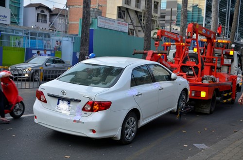 Lực lượng chức năng cầu chiếc xe biển xanh đậu trái phép ở lề đường Nguyễn Thị Minh Khai. Ảnh: CTV Tuấn Anh