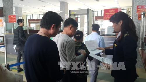 Phát tờ rơi tuyên truyền về dịch cúm A bằng 2 ngôn ngữ Việt - Trung tại cửa khẩu quốc tế Lào Cai. Ảnh: Hương Thu/TTXVN