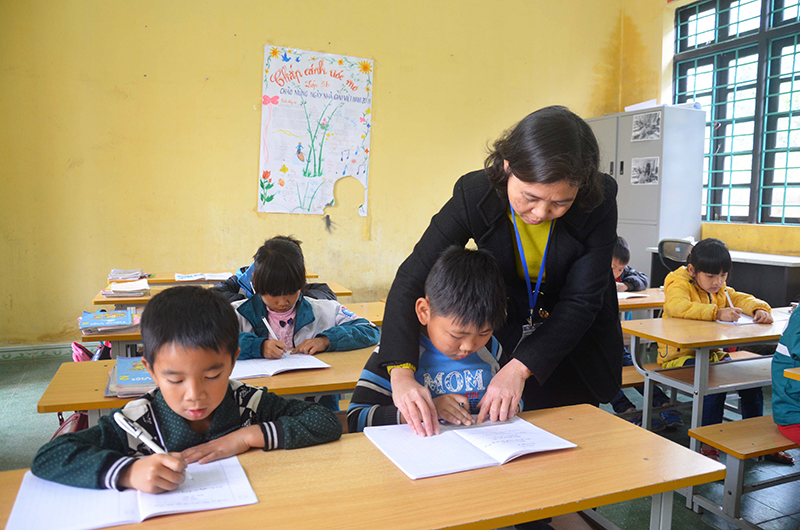 Giáo viên hướng dẫn học sinh lớp 2, điểm trường Đồng Chùa, Trường TH&THCS Vũ Oai, huyện Hoành Bồ làm bài tập tiếng Việt.