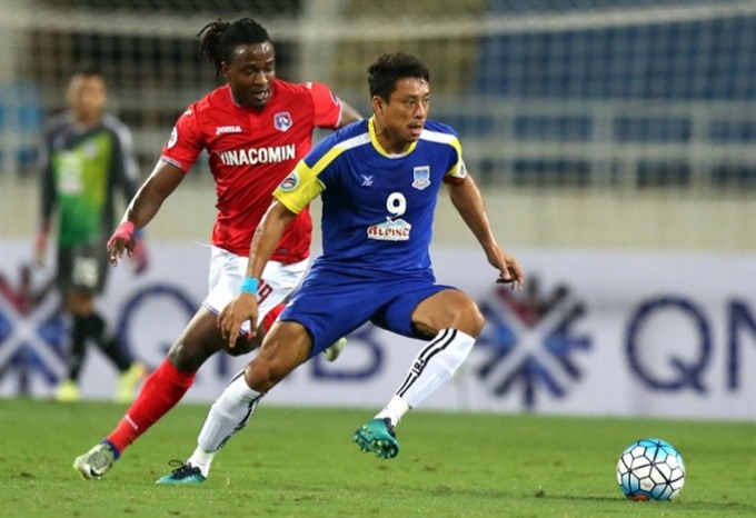 Yadanarbon’s Yan Paing (right) runs a ball away from Geoffrey Kizito of Quang Ninh Coal during their AFC Cup match on March 8 in Ha Noi. — Photo the-afc.com
