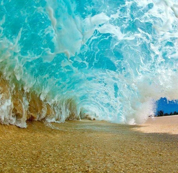 Phía dưới một con sóng đổ vào bờ cát. (Nguồn: boredpanda.com)