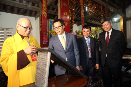Phó Thủ tướng Vũ Đức Đam nghe giới thiệu mộc bản kinh Phật lưu giữ tại chùa. Ảnh: VGP/Đình Nam