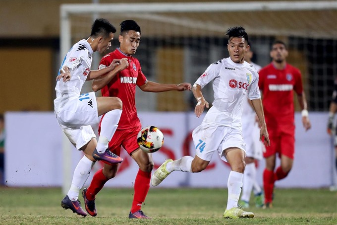  Captain Vu Minh Tuan of Quang Ninh Coal (second, left) vies for a ball in a match in V.league. Tuan will lead his team seeking the first AFC Cup win against Singapore’s Home United at the Jalan Besar Stadium today. — Photo duyendangvietnam.net.vn