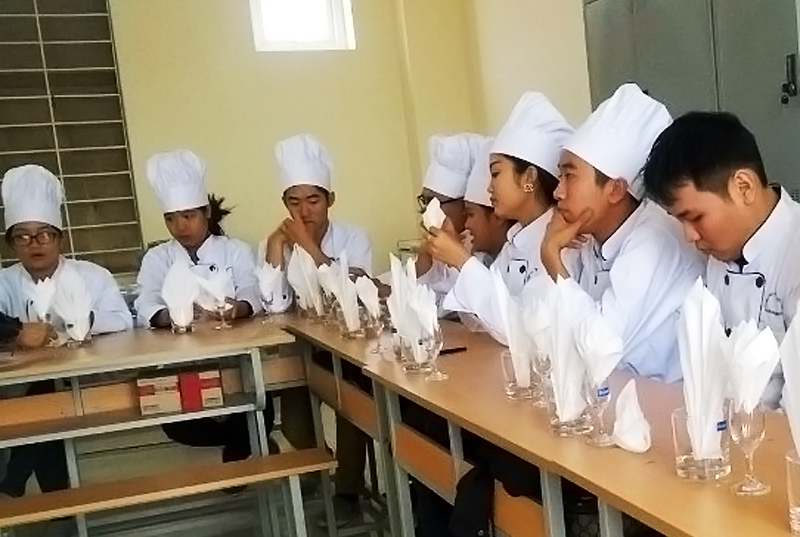 Học viên lớp kỹ thuật chế biến món ăn, Trường Cao  đẳng nghề Việt - Hàn Quảng Ninh nghe hướng dẫn  thực hành cách bài trí bàn ăn.