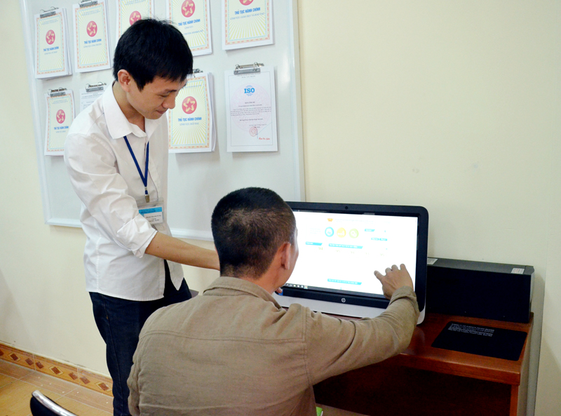 Cán bộ bộ phận tiếp nhận và trả kết quả hiện đại phường Cao Xanh, TP Hạ Long hướng dẫn công dân tra cứu thủ tục hành chính qua hệ thống tra cứu điện tử.