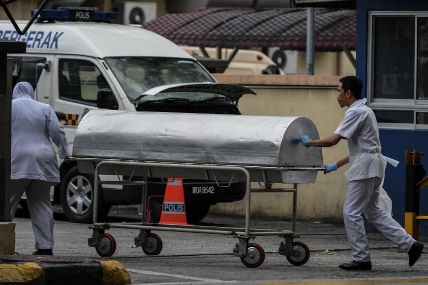 Những nhân viên y tế xuất hiện ở thời điểm di chuyển thi thể ông Kim Chol rời Bệnh viện Kuala Lumpur ngày 26/3. Ảnh: AFP