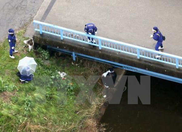 Cảnh sát điều tra tại bờ sông, nơi phát hiện ra thi thể bé Lê Thị Nhật Linh tại Abiko. (Nguồn: Kyodo/TTXVN)
